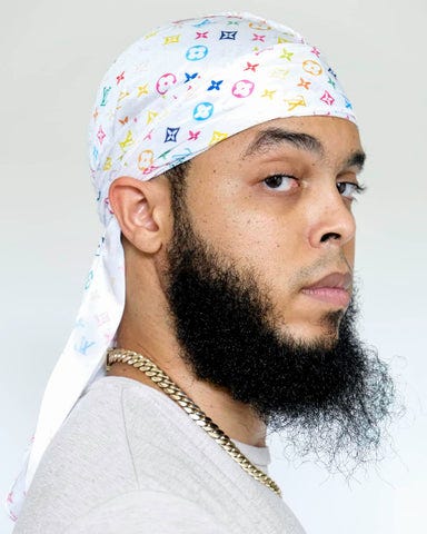 Justin Lewis wearing a white multicolor Louis Vuitton Designer Durag